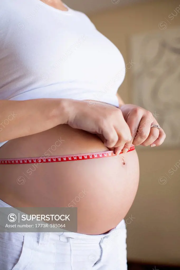 Pregnant woman measuring belly