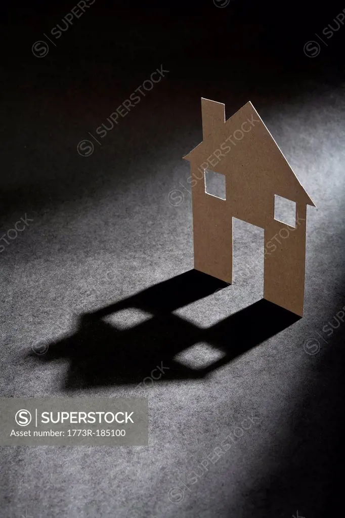 Cardboard house shape casting shadow