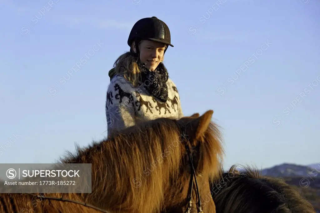 Woman riding horse outdoors
