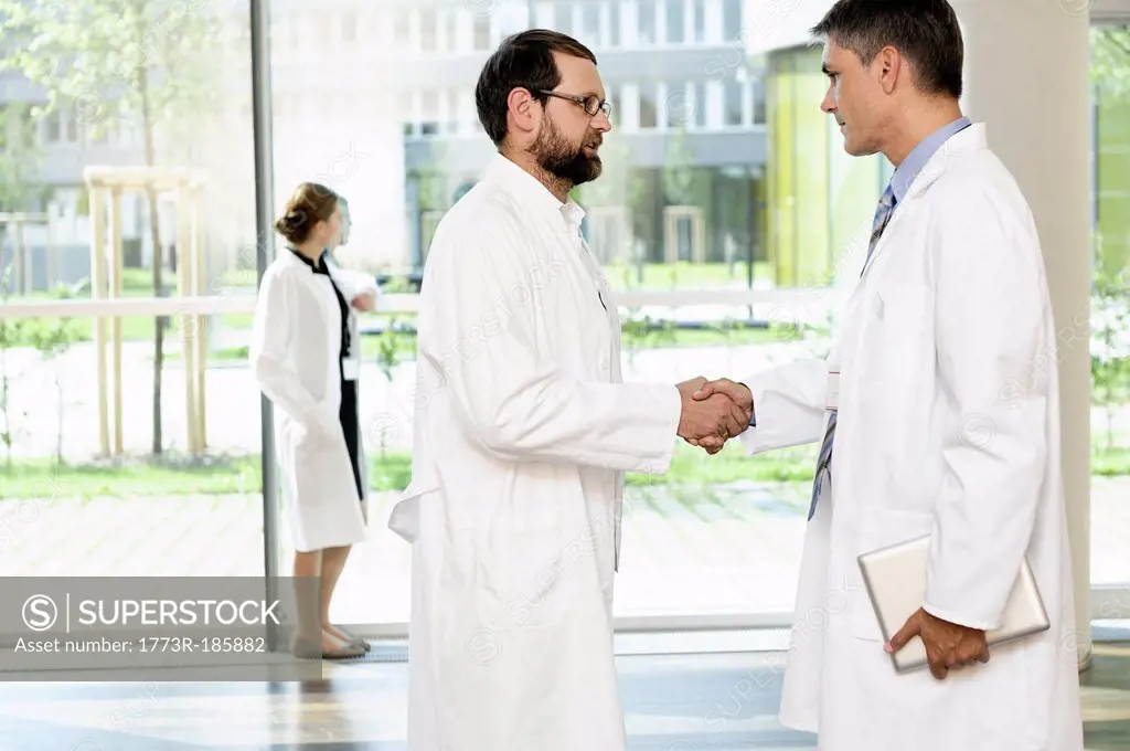 Doctors shaking hands in hallway