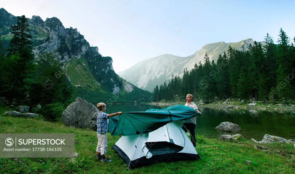 Father and son pitching tent together