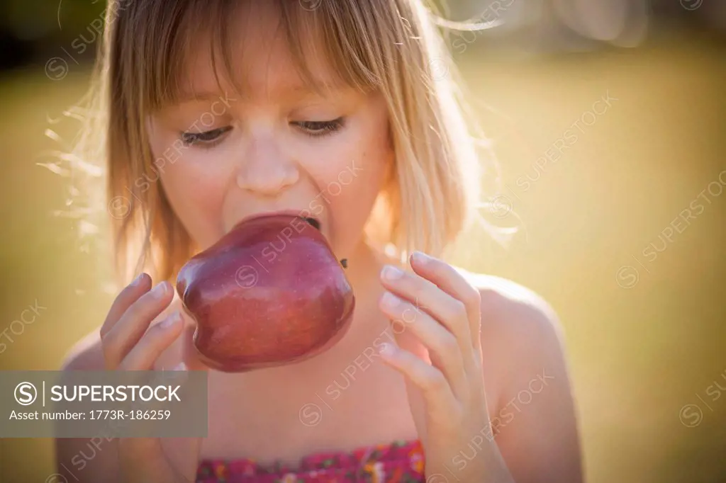 Girl eating apple outdoors