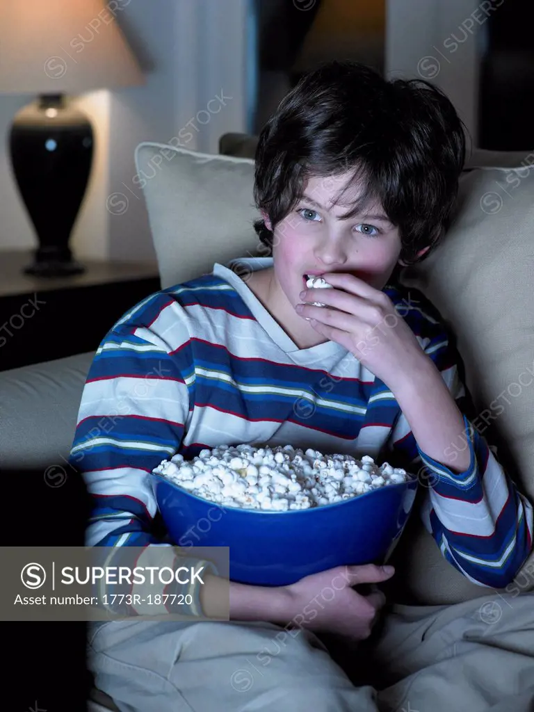 Boy eating popcorn in front of movie