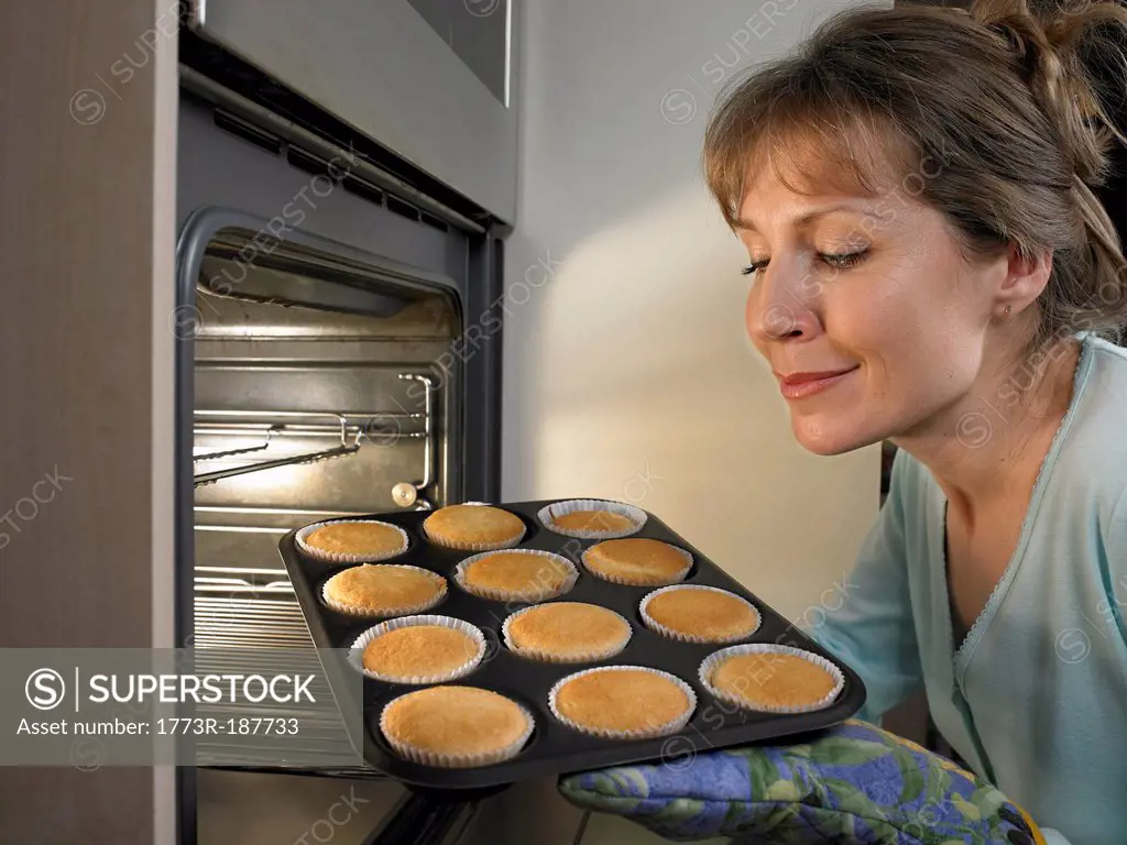Woman baking cupcakes in kitchen