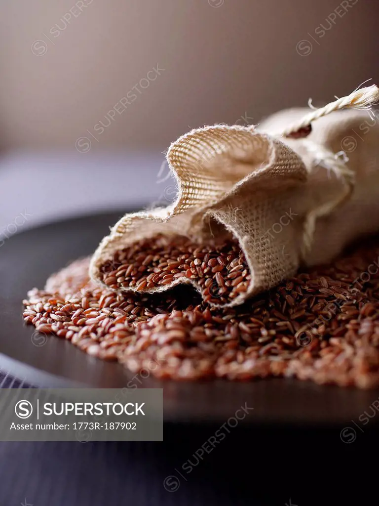 Burlap sack of red rice on plate