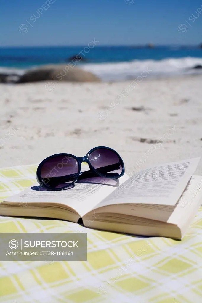 Sunglasses on book on beach