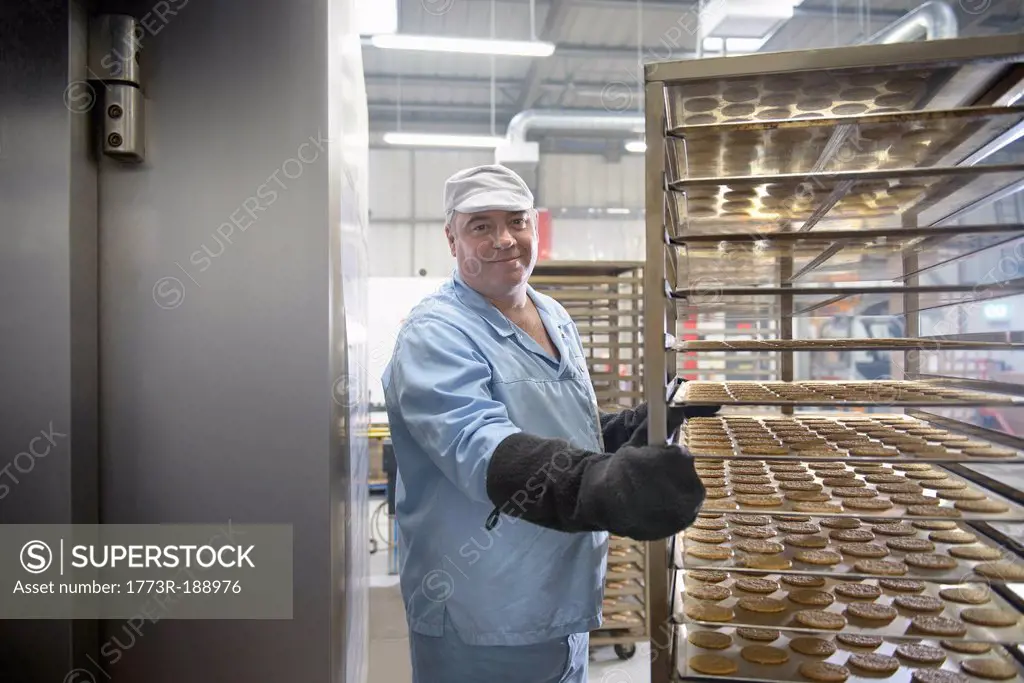 Worker baking biscuits in factory