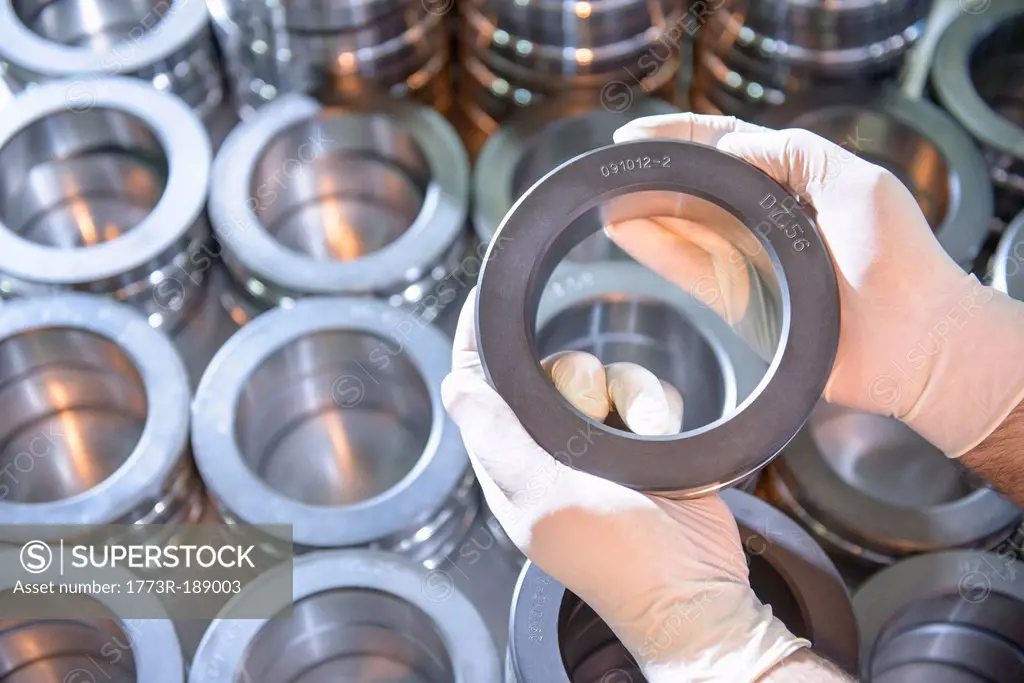 Worker holding steel ring in factory