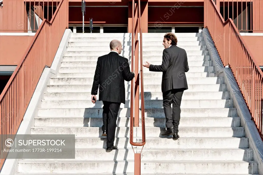 Businessmen ascending staircase, outdoors