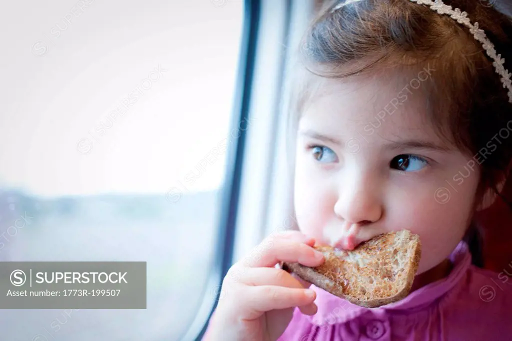 Little girl on train, eating