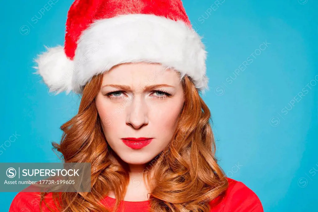 Woman wearing santa hat, frowning