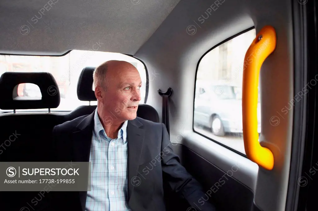 Mature businessman in black cab, London, England, UK