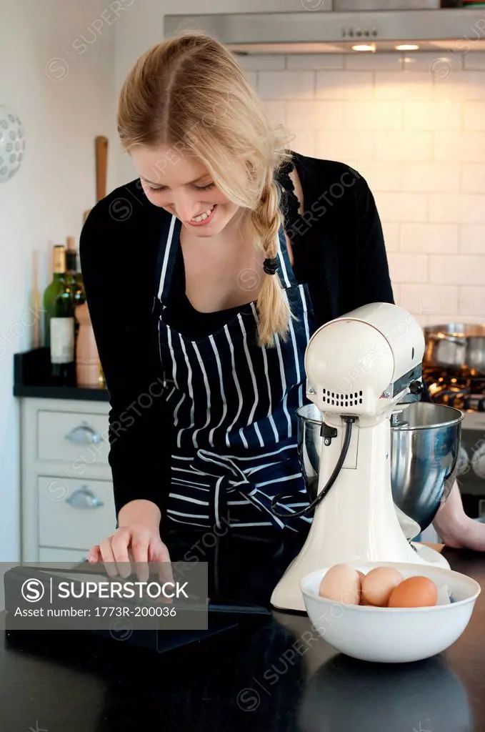 Woman using digital tablet to check recipe