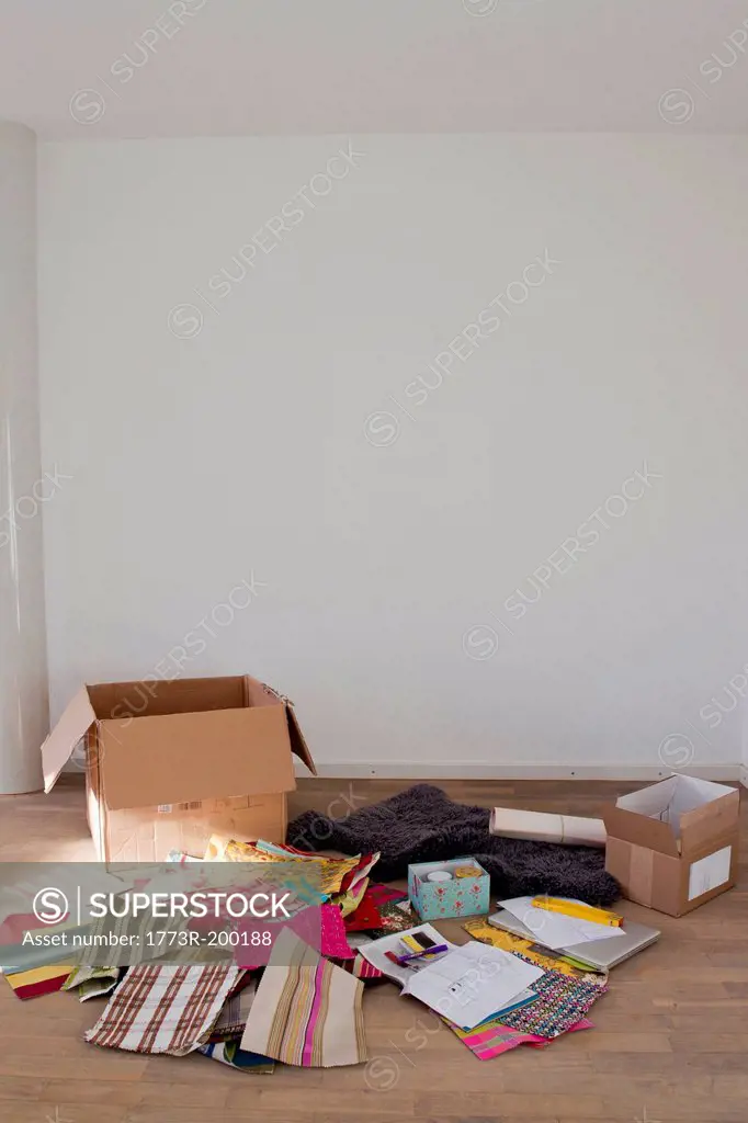 Cardboard box and fabric samples on wooden floor
