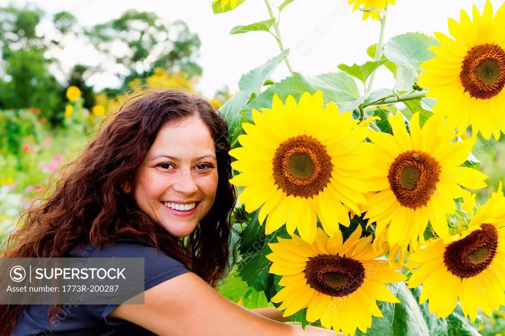 Portrait of young woman and sunflowers in allotment