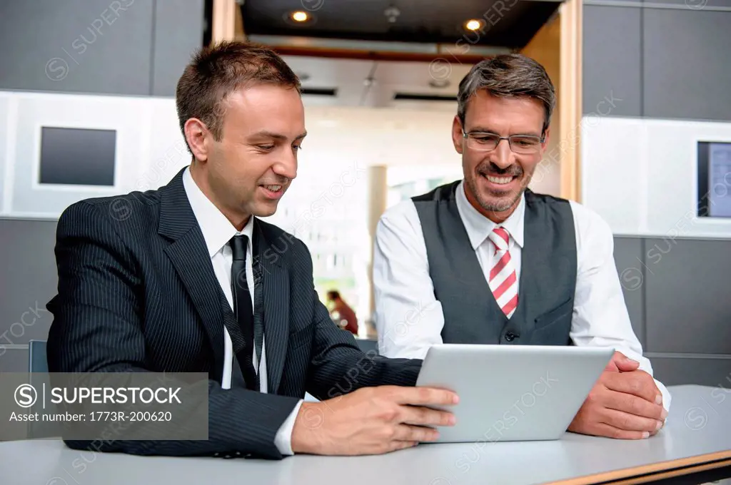 Two businessmen looking at digital tablet