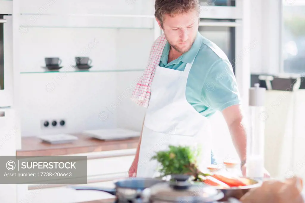 Young man preparing meal in kitchen
