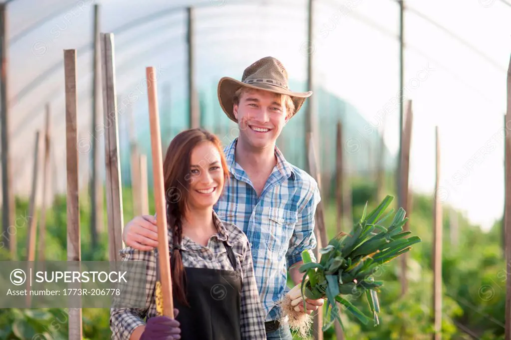 Young woman and man in vegetable greenhouse
