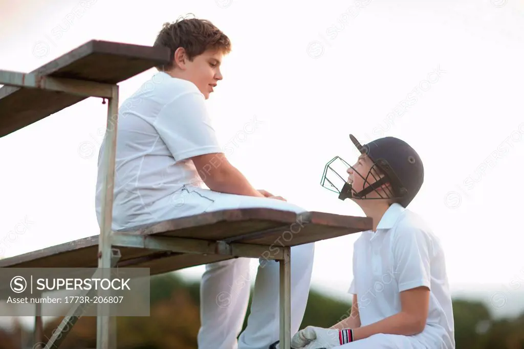 Boys on bleachers at cricket pitch