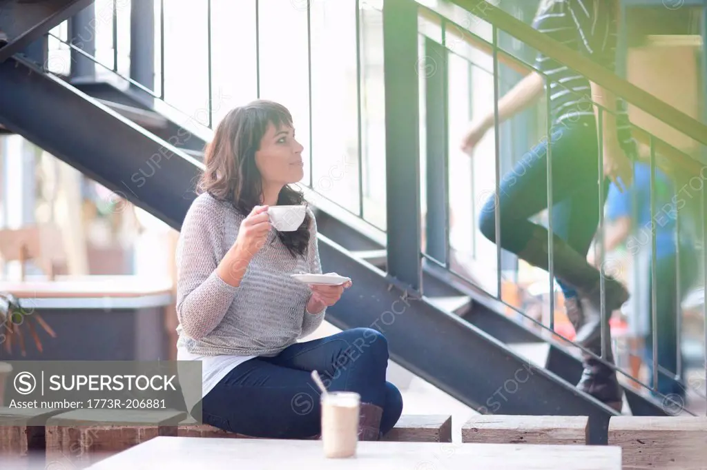 Mid adult woman in cafe with coffee