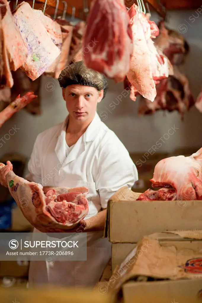 Portrait of butcher holding raw meat