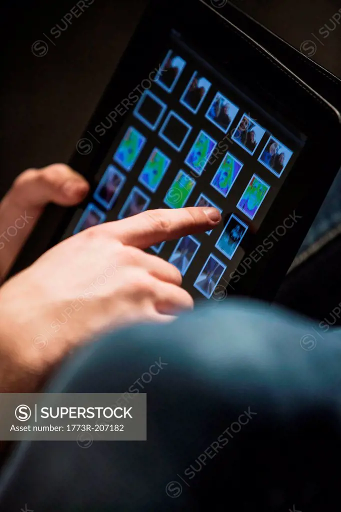 Cropped composition of teenage boy's hand using digital tablet
