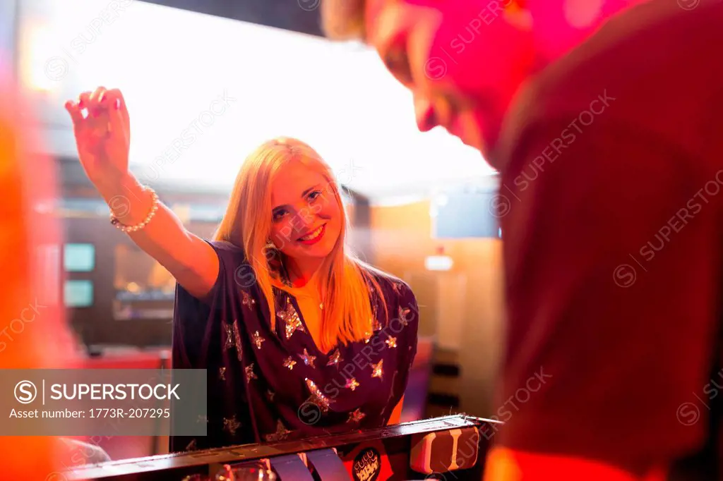 Woman standing in front of disc jockey's mixing desk