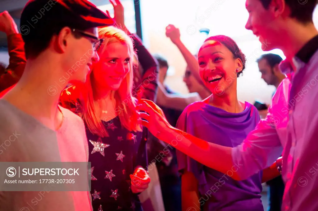 Four young adults laughing at party