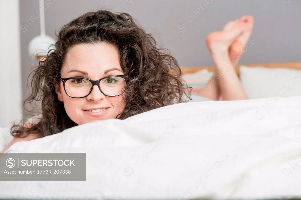 Mid adult woman lying on front on bed