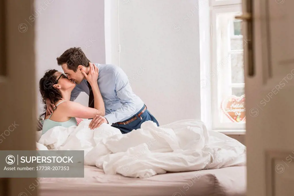 Mid adult couple kissing on bed