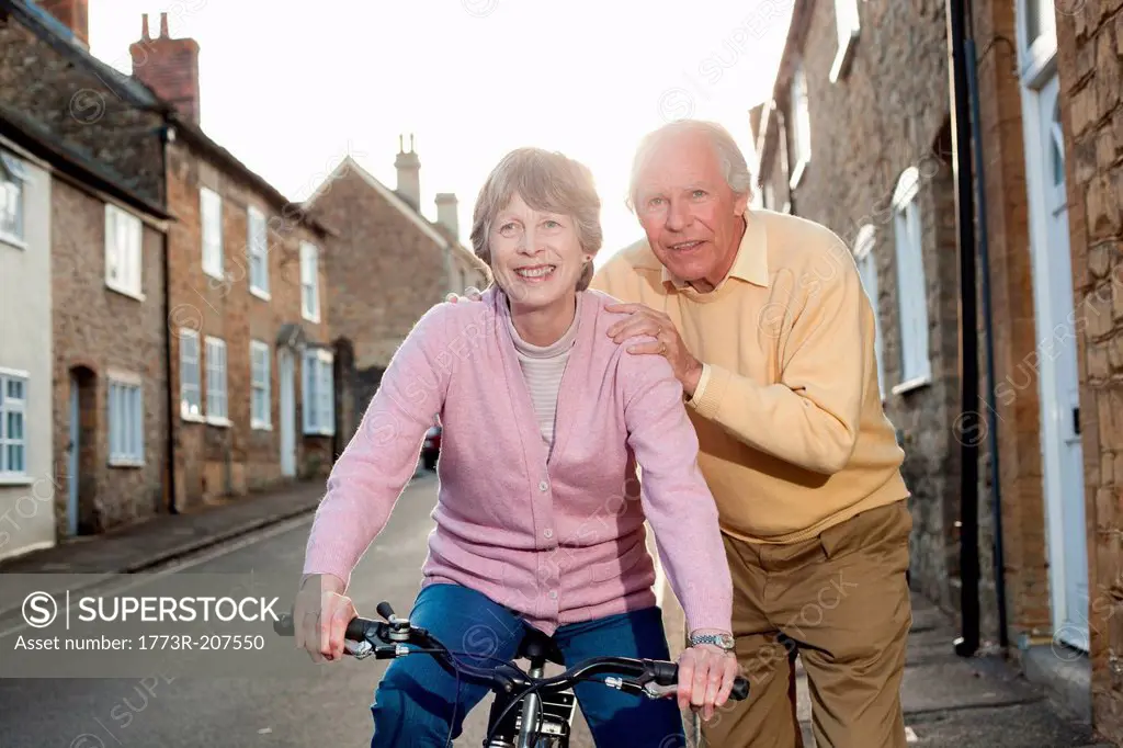 Husband supporting wife on bicycle