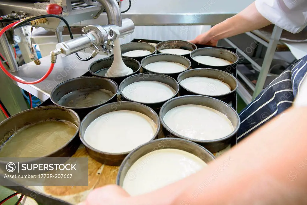 Baker measuring out dough in dishes, close up