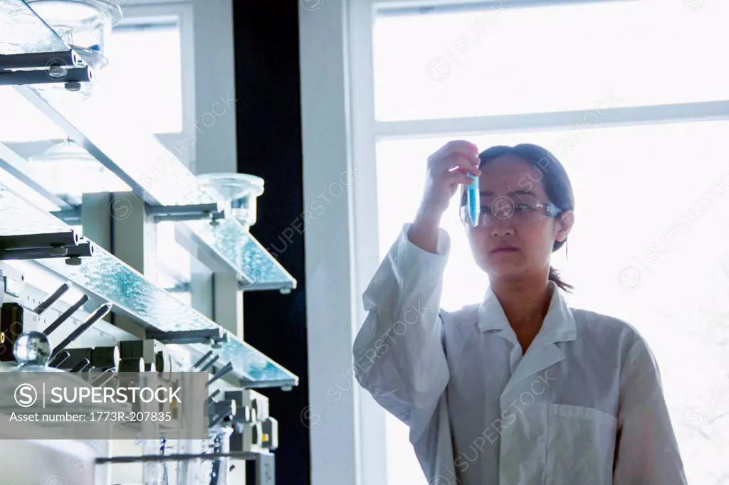 Female scientist looking at test tube