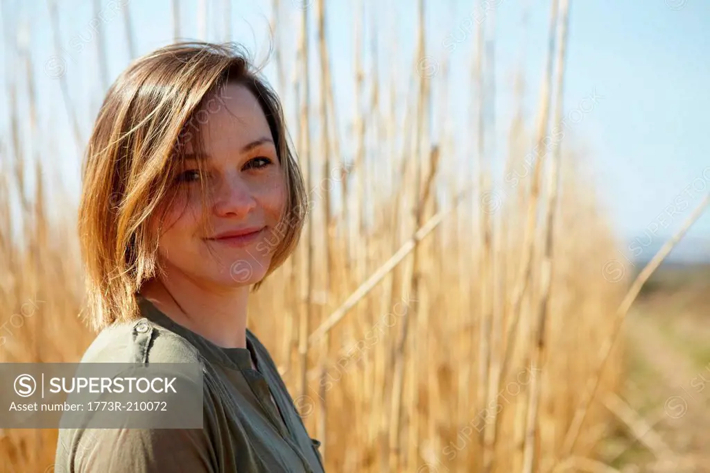 Portrait of young woman in front of reeds