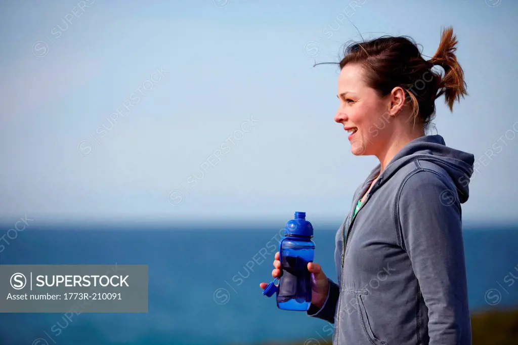 Young woman at coast taking exercise break