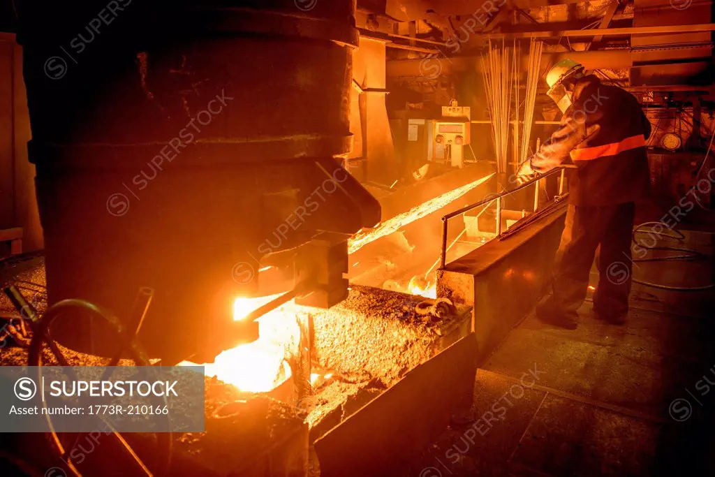 Steel worker attending furnace in steel foundry