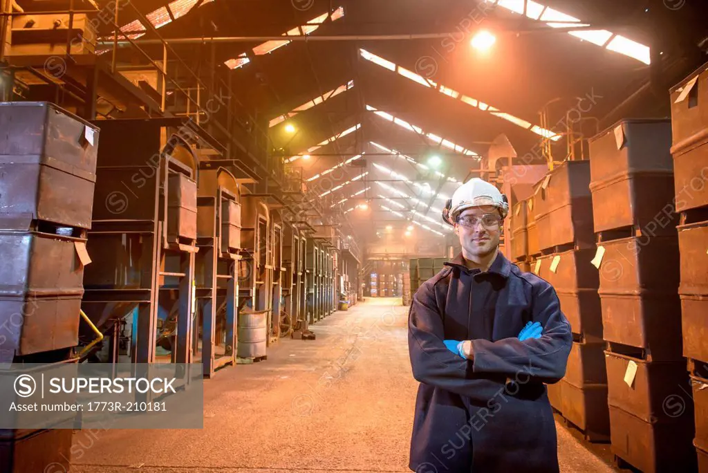Portrait of worker next to crates of steel shot in steel foundry