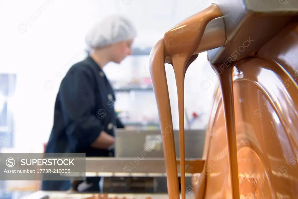 Liquid chocolate running through machine in sweet factory