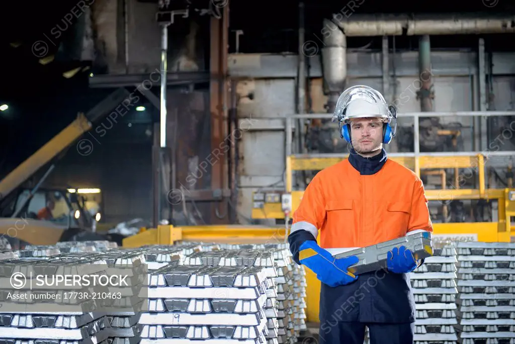 Portrait of warehouse worker holding aluminum ingot