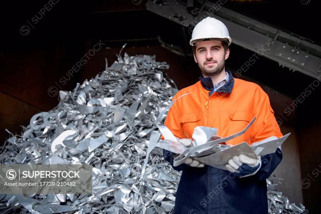 Portrait of worker holding scrap aluminum