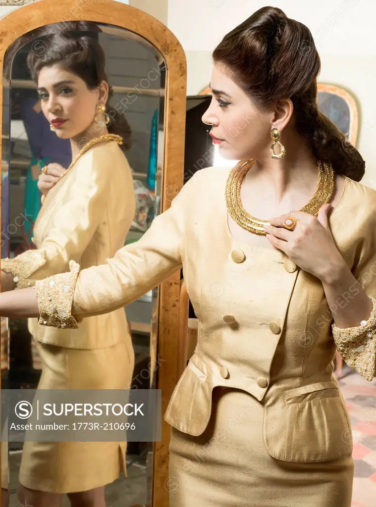 Woman in vintage clothes looking in mirror