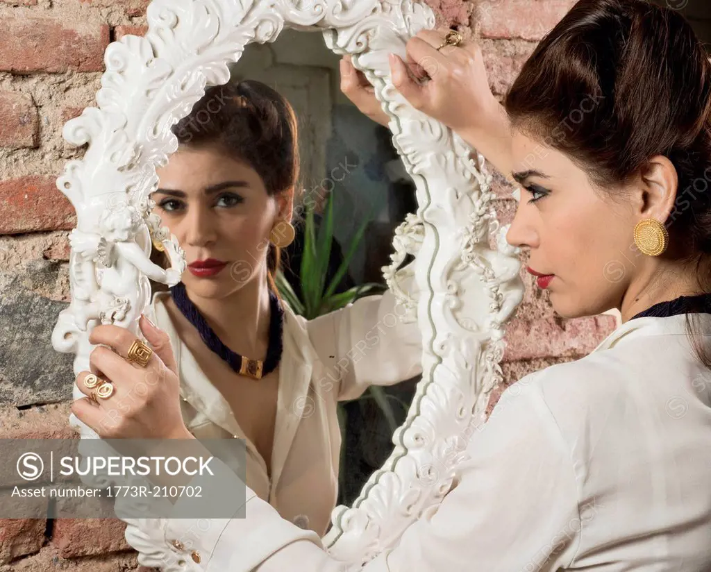 Woman in vintage clothes holding mirror