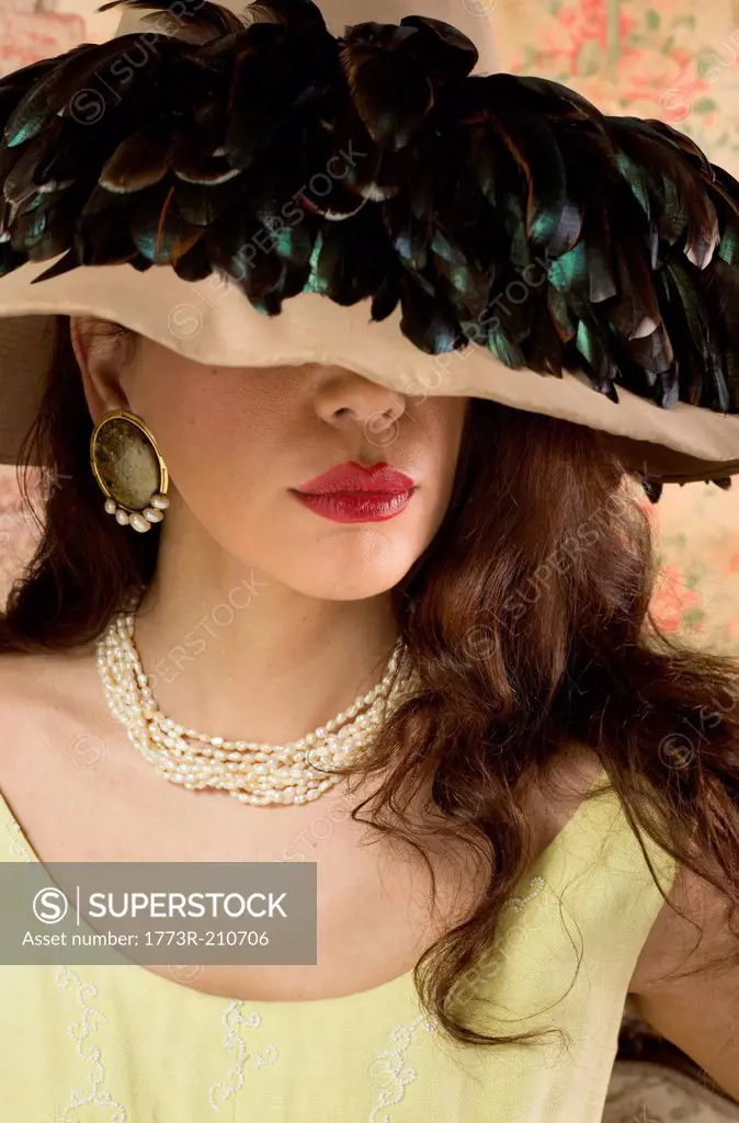 Woman in wide brimmed hat with feathers