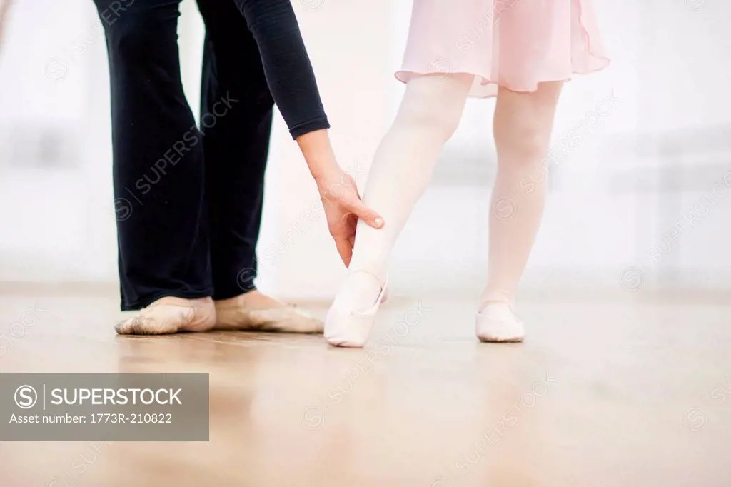 Close up of a young ballerina and teacher practicing toe point