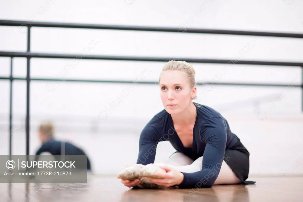 Female ballerina stretching on the floor