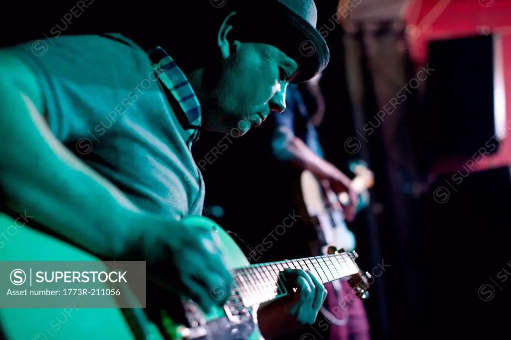 Man playing guitar on stage in nightclub