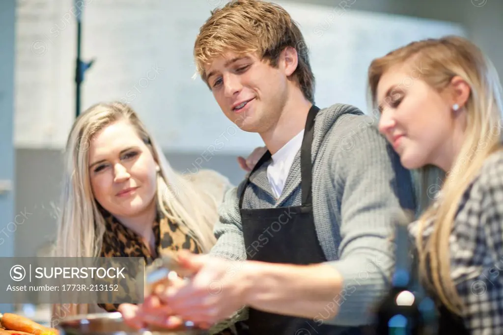 Young adults preparing food in kitchen