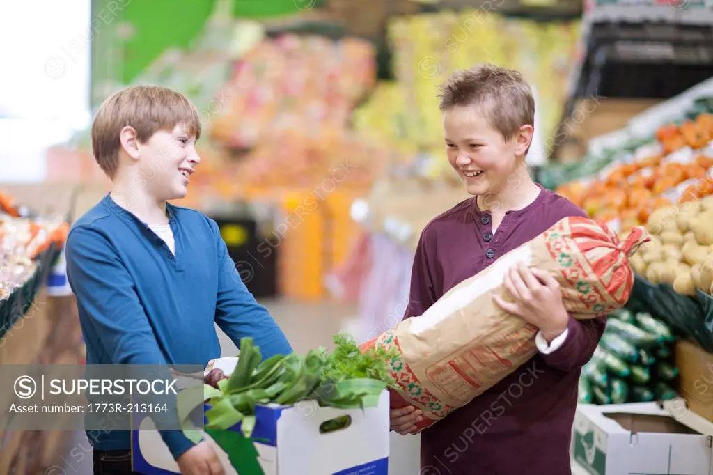 Young boys carrying vegetables in indoor market