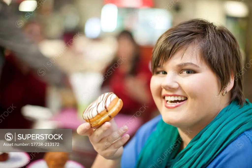 Portrait of young woman holding doughnut