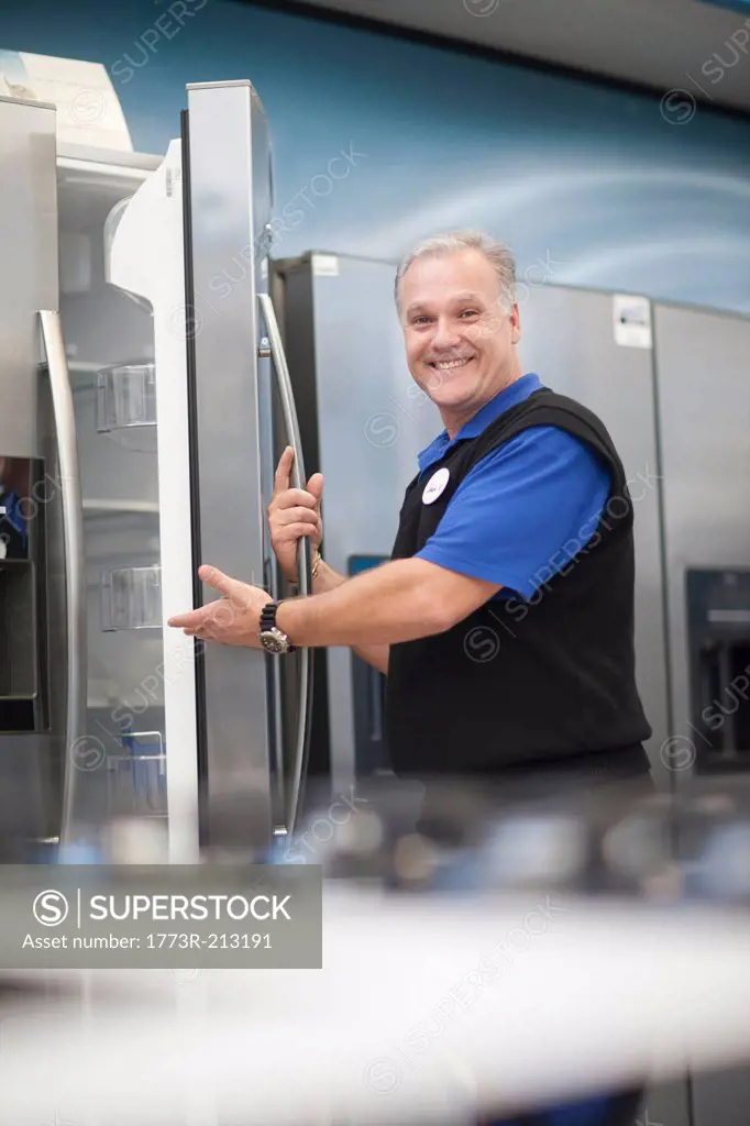 Salesman showing fridge in showroom